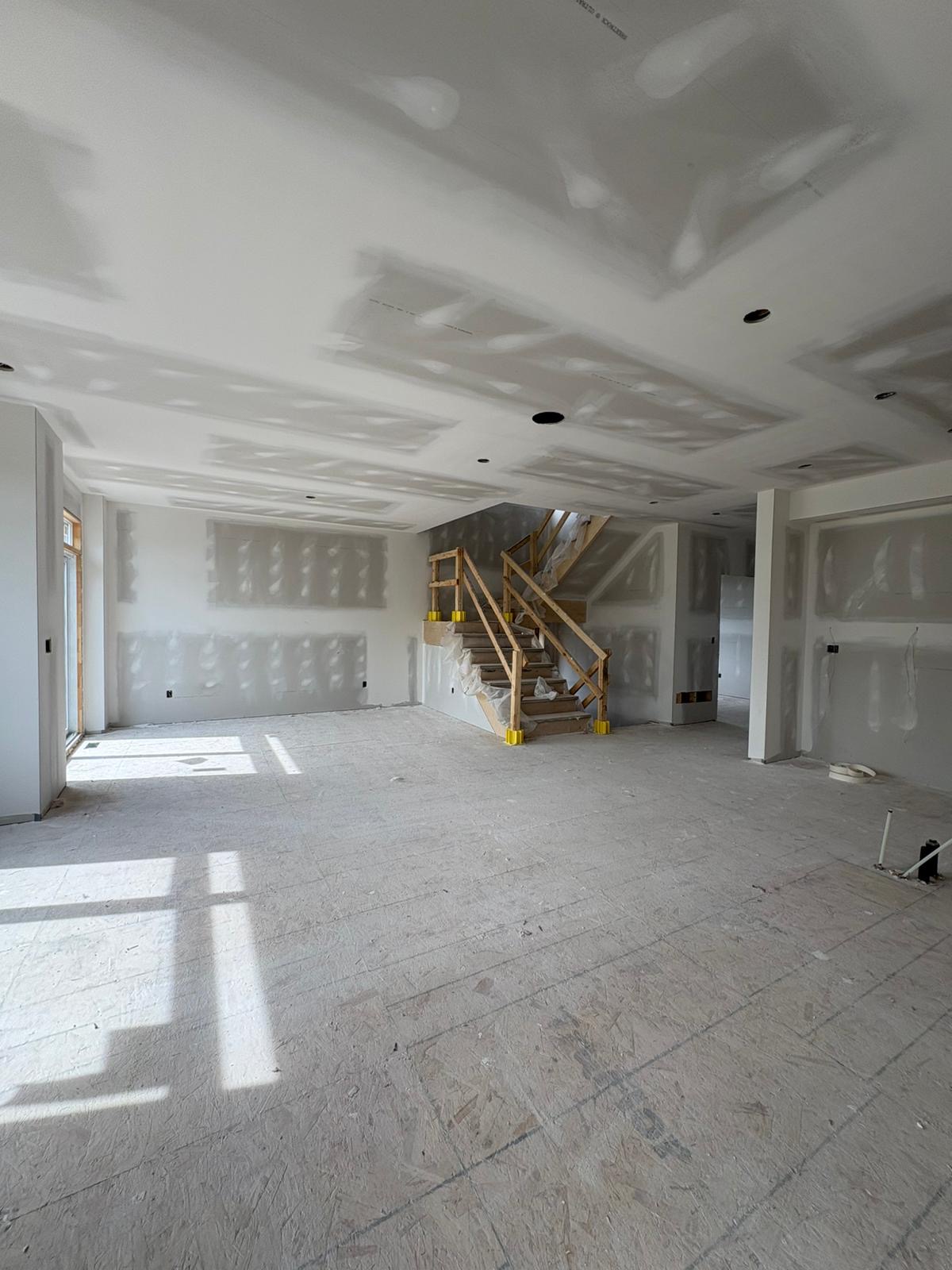 Main floor drywall with staircase and taped ceiling