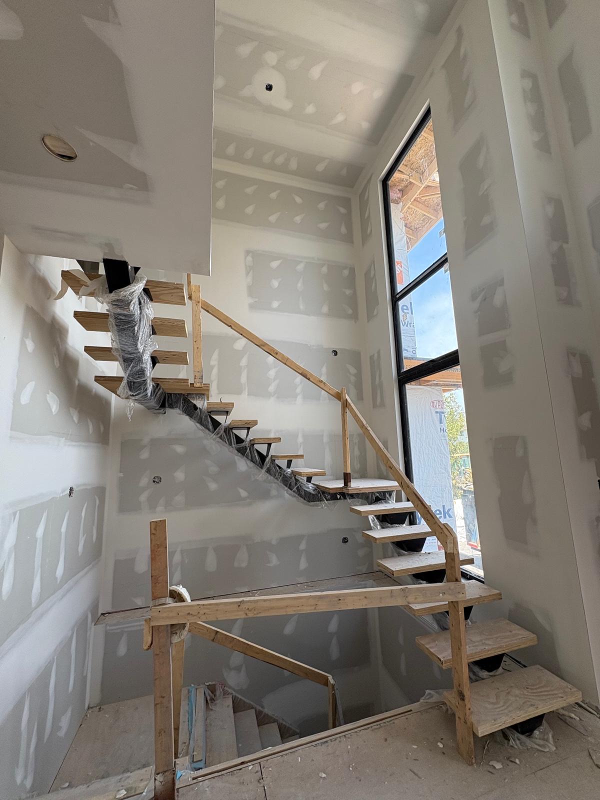 Stairwell drywall with tall window opening