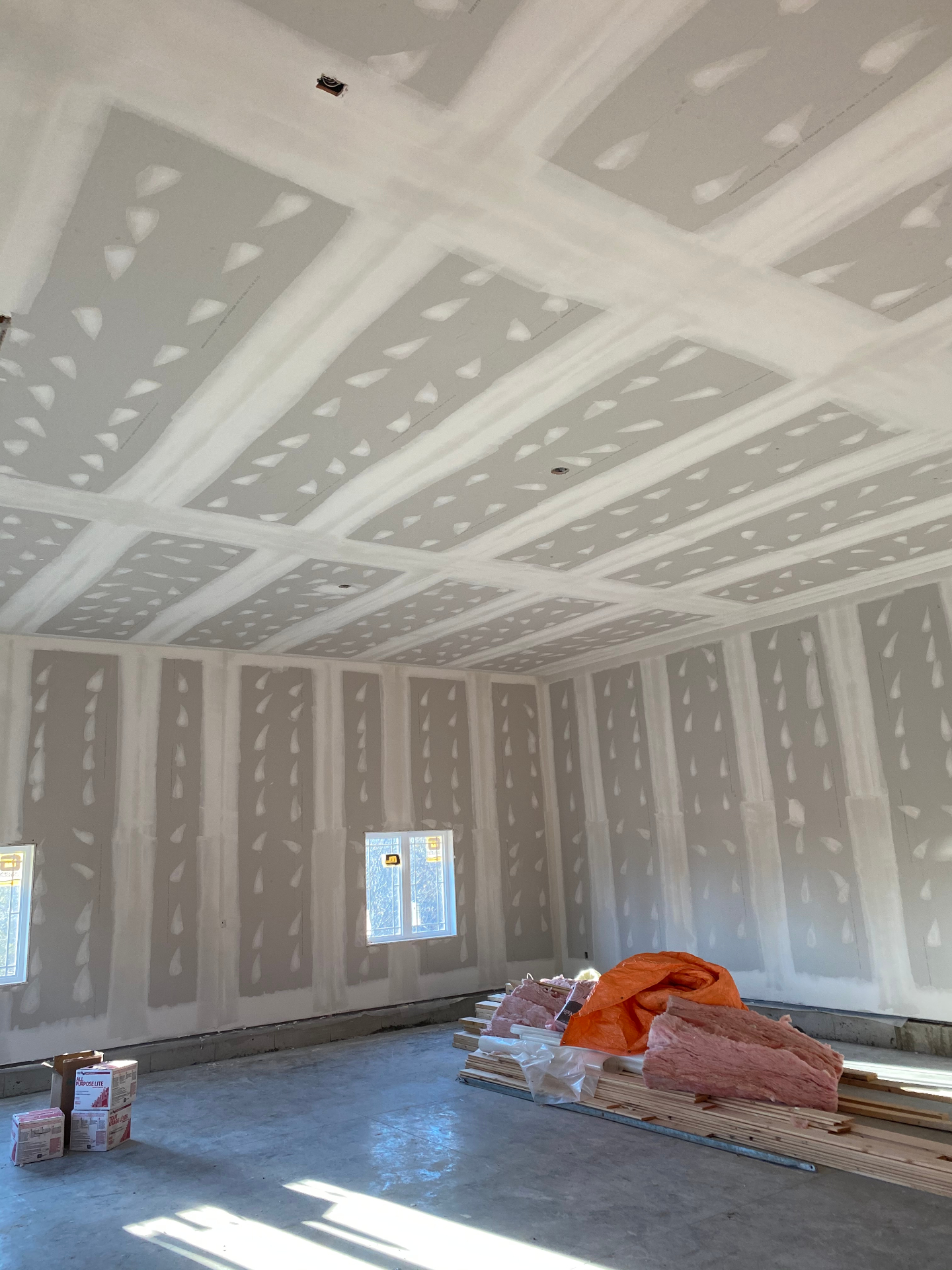 Board and taping progress on walls and ceiling